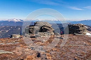 Rear view of woman with backpack hiking on snow covered alpine meadow to Steinerne Hochzeit, Saualpe, Lavanttal Alps photo