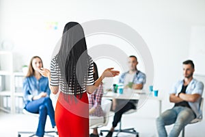 Rear view of woman business coach gesturing with hand