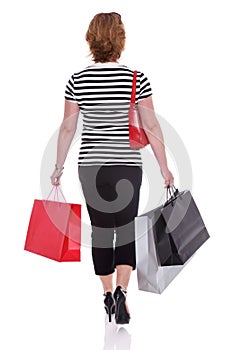 Rear view of a woman carrying shopping bags isolated.