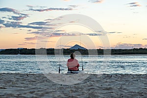 Rear View of Woman Fishing on the Beach at Sunset Time in Noosa, Australia.Lifestyle Concept