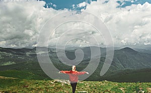 Rear view woman hiker standing on top of mountain with open arms. Feeling freedom and harmony.