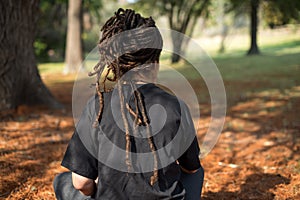 Rear View of woman with locs sitting outside