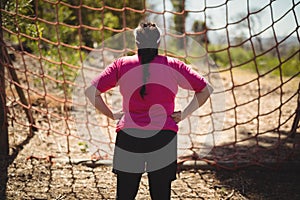 Rear view of woman looking at net during obstacle course