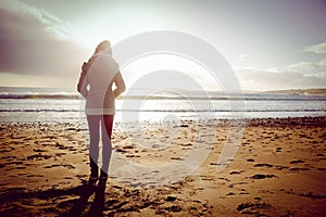 Rear view of woman looking at the sea during the sunset