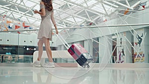 Rear view woman with luggage walking towards private jet at airport terminal, happy student tourist in dress and