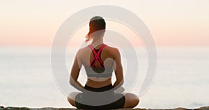 Rear view, woman and meditation for yoga on beach or wellness, zen and relax for exercise or workout. Young lady, sunset