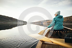 Rear view of woman paddling canoe