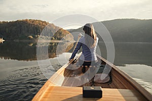 Rear view of woman paddling canoe on lake