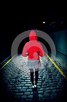 Rear View Of Woman In Red Hood On Street At Night