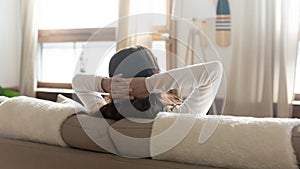 Rear view of woman relax on sofa looking in distance