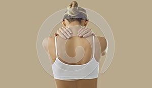 Rear view of woman suffering from neck pain due to muscle spasm or nerve entrapment.