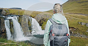 Rear view of woman tourist enjoying Kirkjufellsfoss in northern Iceland