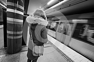 rear view of woman waiting for a subway train in city of Stockholm Sweden