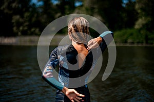 Rear view of woman in wetsuit with the zipper open.