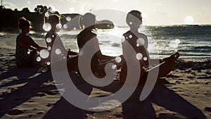 Rear view of women mediating on sand