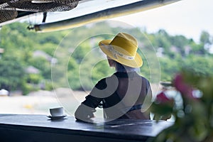 Rear view of young Asian beauty sitting, relaxing at beach bar in vacation