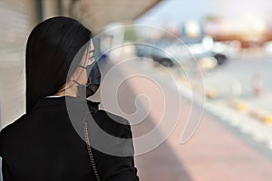 Rear view young asian business woman in business black suit with protect mask for healthcare walking on street public outdoor and