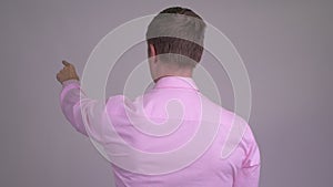 Rear view of young businessman directing and pointing finger