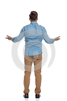 Rear view of a young casual man welcoming