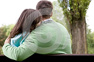 Rear view of young couple sitting on bench