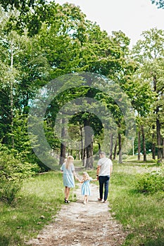 Rear view of young family walking in forest