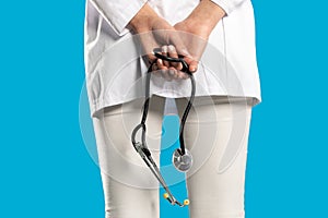 Rear view while young female doctor`s hands holding a stethoscope