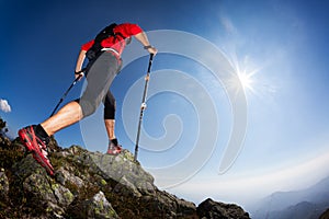 Rear view of a young male runner walking along a mountain trail