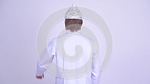 Rear view of young man doctor with tinfoil hat as conspiracy theory concept