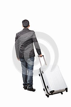 Rear view of young man and pulling belonging luggage walking to photo