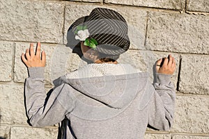 Rear view of young teen girl in gray jacket standing next to th