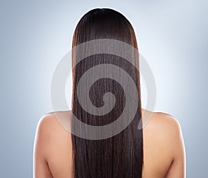 Rear view of a young woman with beautiful long smooth hair. Close up of a woman with luxurious straight and shiny brown