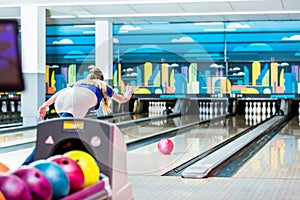 Rear view of a young woman bowling