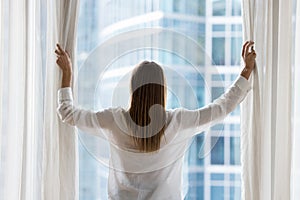 Rear view of young woman in casual opening drapes