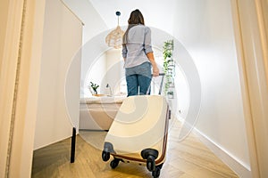 Young woman entering a hotel room with her luggage photo