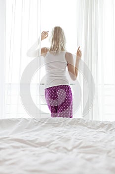 Rear view of young woman looking through hotel window