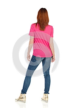 Rear View Of Young Woman In Pink Shirt And Gold Sneakers