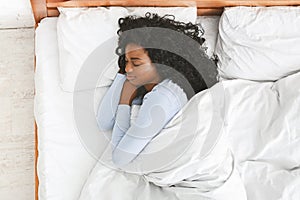 Rear view of young woman sleeping in her bed