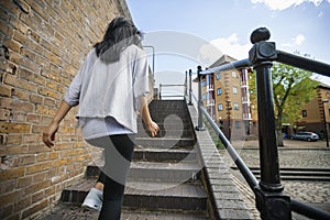 Rear view of young woman walking up stairs