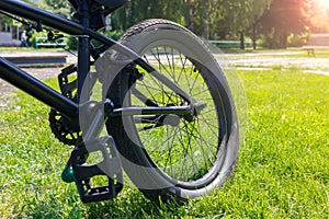 Rear wheel of a bicycle close up on grass on a bright, sunny day