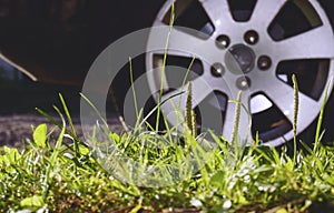 Rear wheel of a car parked on the grass