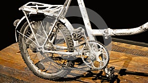 the rear wheel of an old bicycle with pedals and a rack