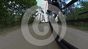 Rear wheel view of MTB bicycle. Chain drive, rear derailleur, cassette. Bicyclist rides mountain bike along sandy road