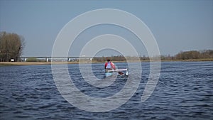 Rear wide view of Athlete rowing on the river in a canoe. Rowing, canoeing, paddling. Training. Kayaking. Man sailing