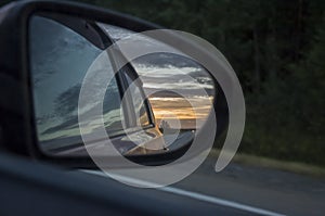 Rear window of auto with view of sundown landscape