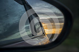 Rear window of auto with view of sundown landscape