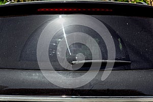 Rear window of a black dirty car.