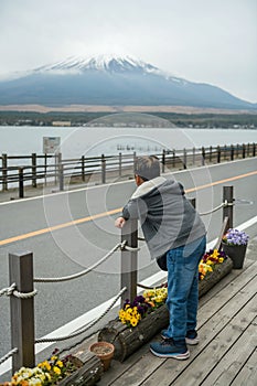 Rear of young Asian boy at lake yamanakako look at mount Fuji