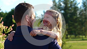 Rear of young happy father holding his little daughter and smiling. Close up of pretty cute child with dad outside in