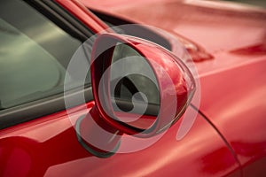 Rearview mirror. Part of a red car close up