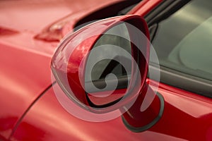 Rearview mirror. Part of a red car close up